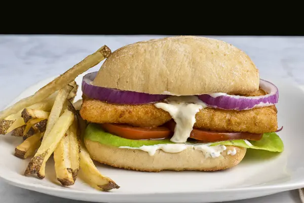 Domatesli mezgit fileto sandviç, I; ciabatta rulo üzerinde ettuce ve soğan patates kızartması ile servis edilir.