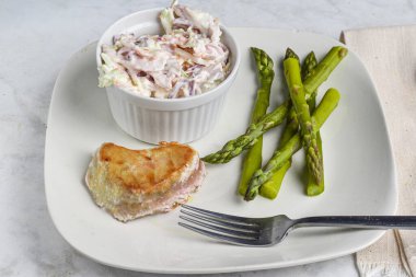 Lahana salatasıyla servis edilen kuşkonmaz ile ton balığı bifteği.