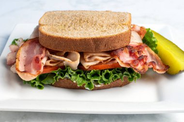 Domates, marul ve hindili pastırma buğday ekmeğinde servis ediliyor., 