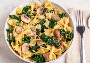 Farfalle makarna sotelenmiş ıspanak ve parmesan peynirli mantarla servis edilir.