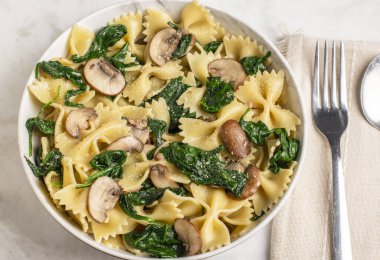 Farfalle makarna sotelenmiş ıspanak ve parmesan peynirli mantarla servis edilir.