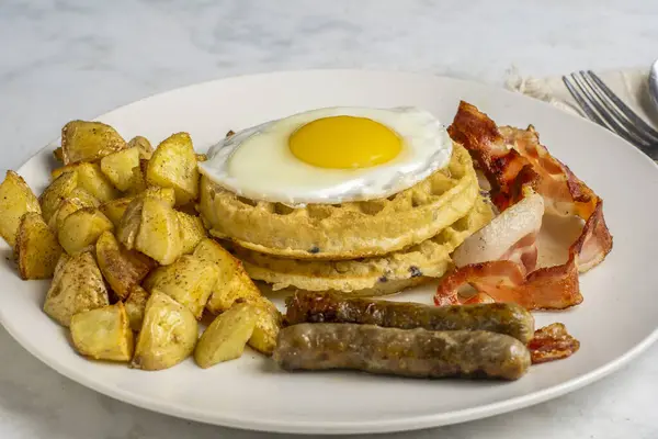 Pastırma, sosis ve patates kızartması ile servis edilen omlet..