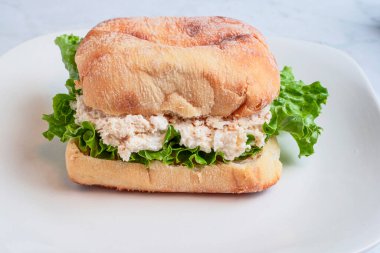 chicken  salad  on lettuce served on a ciabatta roll  with a pickle, clipart