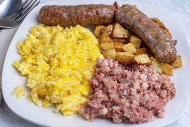 Çırpılmış yumurta, tatlı İtalyan sosisi, patates kızartması ve mısır gevreği.,