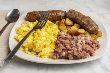 Çırpılmış yumurta, tatlı İtalyan sosisi, yanında mısır gevreği ve patates kızartması..
