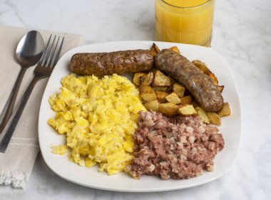 Çırpılmış yumurta, tatlı İtalyan sosisi, yanında mısır gevreği ve orangutan suyu.