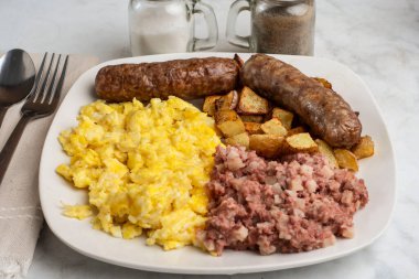 Çırpılmış yumurta, tatlı İtalyan sosisi, yanında mısır gevreği ve patates kızartması..