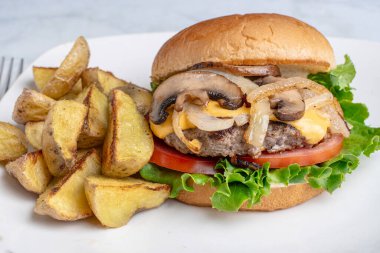 Peynirli burger üstü sotelenmiş soğan ve patates dilimli mantar.