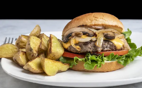 Peynirli burger üstü sotelenmiş soğan ve patates dilimli mantar.