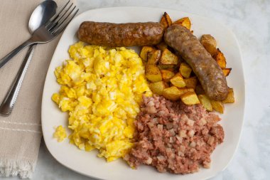 Çırpılmış yumurta, tatlı İtalyan sosisi, patates kızartması ve mısır gevreği.,
