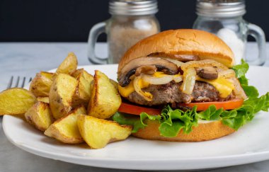 Peynirli burger üstü sotelenmiş soğan ve patates dilimli mantar.