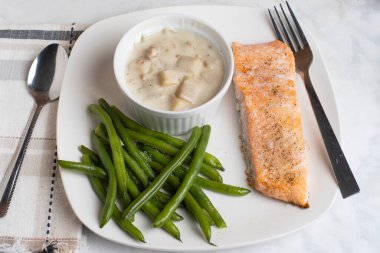 Tuz ve deniz tarağı çorbasıyla baharatlı yeşil fasulyeli somon.