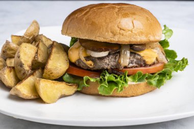 Peynirli burger üstü sotelenmiş soğan ve patates dilimli mantar.