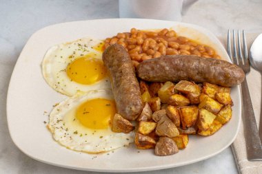 Sosisli yumurta, fırında fasulye ve patates kızartması.
