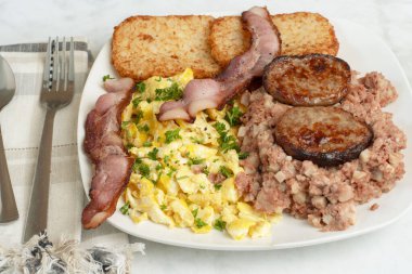 Çırpılmış yumurta, maydanozlu domuz pastırması, sosisli börek ve mısır köftesi.