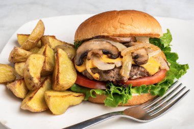 Peynirli burger üstü sotelenmiş soğan ve patates dilimli mantar.