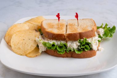 Patates cipsi ve turşulu kızarmış tavuklu sandviç., 