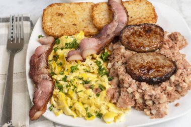 Çırpılmış yumurta, maydanozlu domuz pastırması, sosisli börek ve mısır köftesi.