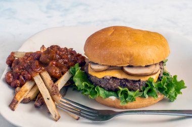 Peynirli burger üstü ve mantarlı çörek ve acılı patates kızartması.