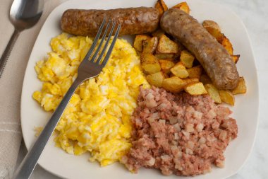 Çırpılmış yumurta, tatlı İtalyan sosisi, yanında mısır gevreği ve patates kızartması..