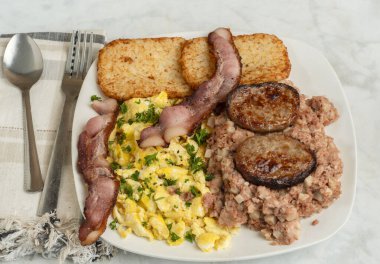 Çırpılmış yumurta, maydanozla servis edilmiş mısır, domuz pastırması ve sosisli börek.,