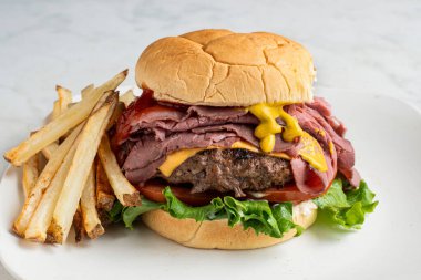 Peynirli brurger üstü, kızarmış biftekli ve kızarmış patatesli.,.