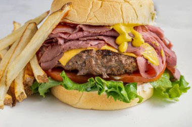 Peynirli brurger üstü, kızarmış biftekli ve kızarmış patatesli.,.