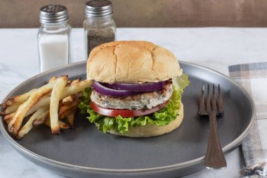 Patates kızartması ve salatalı tavuk köftesi, domates ve soğan.