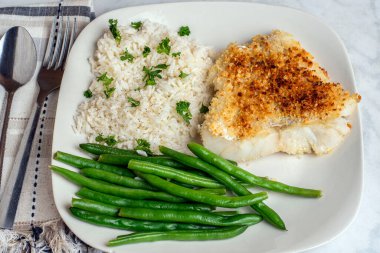  Fırında mezgit, pirinç, maydanoz ve yeşil fasulye ile servis edilir.