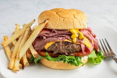 Peynirli brurger üstü, kızarmış biftekli ve kızarmış patatesli.,.