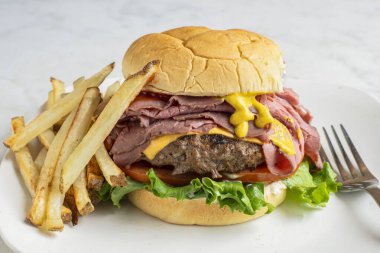 Peynirli brurger üstü, kızarmış biftekli ve kızarmış patatesli.,.