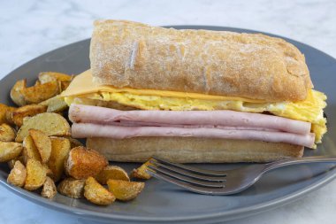 Jambonlu ve peynirli omlet ve ciabatta, yanında da patates kızartması.