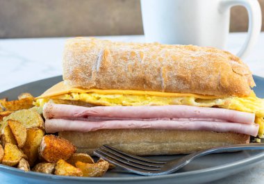 Jambonlu ve peynirli omlet ve ciabatta, yanında da patates kızartması.