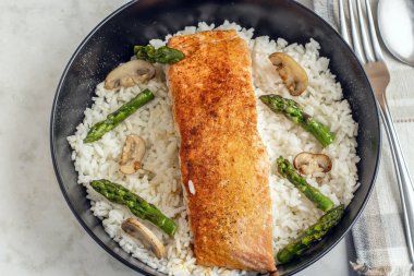 kuşkonmaz ve mantarla pişirilmiş beyaz üzerine baharatlı somon balığı.