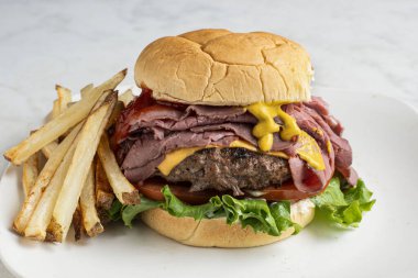 Peynirli brurger üstü, kızarmış biftekli ve kızarmış patatesli.,.