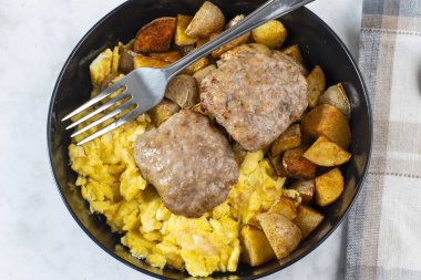 Patates kızartması ve sosisli börekle servis edilmiş omlet.