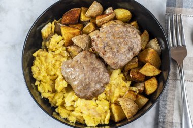 Patates kızartması ve sosisli börekle servis edilmiş omlet.