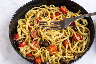 Domates ve zeytinle servis edilen pesto soslu linkin.