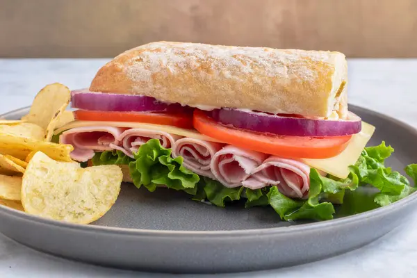 marul, domates, peynir ve jambonlu soğan cipsle servis edilir.