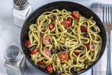 Domates ve zeytinle servis edilen pesto soslu linkin.