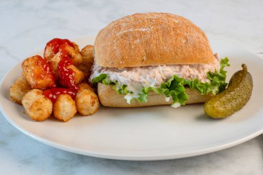 Ciabatta rulosunda marullu ton balığı salatası. Ketçaplı patates kroket ile servis ediliyor..