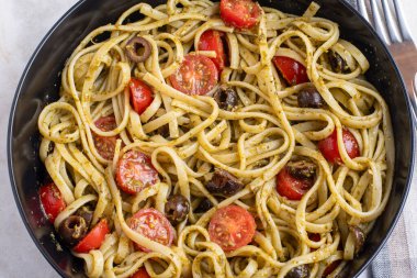 Domates ve zeytinle servis edilen pesto soslu linkin.