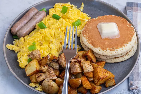 Tereyağlı gözleme, çırpılmış yumurta, sosis ve patates kızartması.