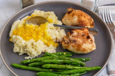 Patates püresiyle servis edilen tavuk budu kremalı mısır ve yanında sotelenmiş yeşil fasulye..