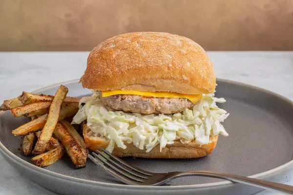 hindi burger, lahana salatası ve peynirli ciabatta rulo ile servis edilen ev yapımı patates kızartması.