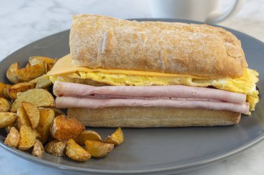 Jambonlu ve peynirli omlet ve ciabatta, yanında da patates kızartması.