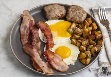  Domuz pastırmalı sahanda yumurta ve patates kızartmasıyla servis edilen sosisli börek.