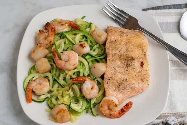  Baharatlı fırında somon, kabaklı şehriye, deniz tarağı ve karides ile servis edilir.