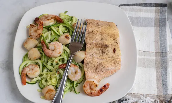  Baharatlı fırında somon, kabaklı şehriye, deniz tarağı ve karides ile servis edilir.