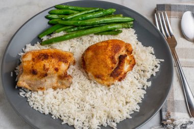 yeşil fasulyeyle servis edilen pilavlı tavuk butları.